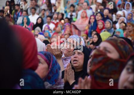 April 14, 2018 - Srinagar, Jammu und Kaschmir, Indien - Kaschmir Frauen Weinen und bitten um den Segen für die Heiligen Reliquien, geglaubt, ein Haar von der Bart des Propheten Mohammed PBUH wird von heiligen Priester (gerahmt) Anlässlich der Mehraj-ul angezeigt werden - Nabi bei Hazratbal Schrein in Srinagar, Sommer, die Hauptstadt der Indischen verwalteten Kaschmir. Jedes Jahr Tausende von muslimischen Gläubigen aus ganz Kaschmir Raffungen an Hazratbal Schrein im Zentrum Srinagar Sommer Hauptstadt des indischen Kaschmir für Gebete und die heilige Reliquie zu beobachten (MOE-e-moqadas) geglaubt, ein Haar von der Bart des Propheten Mohammed PB zu sein Stockfoto