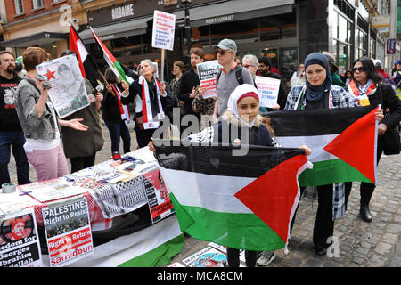 London, Großbritannien, 14. April 2018 muslimische Mädchen und ihre Mutter holding Palästinensischen Fahnen auf die palästinensischen Rechte demo gegenüber der israelischen Botschaft in Kensington, London, Vereinigtes Königreich. Die etwas rauhe Demonstration war recht gut mit rund 60 anwesenden Personen unterstützt. Es war infolge der jüngsten Gewalt zwischen den beiden Seiten aufgerufen, über die anhaltenden Spannungen im Gazastreifen zu protestieren. London, Großbritannien, 14. April 2018 sammeln von Fünf pro-israelischen Demonstranten gehechelt, die Demonstration von der anderen Seite der Straße. Quelle: Michael Preston/Alamy leben Nachrichten Stockfoto