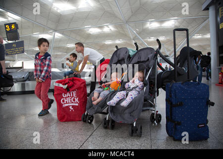 10 Monate altes Baby Zwillinge in einem Doppelbuggy unbeaufsichtigt am Stansted Airport, Großbritannien Stockfoto