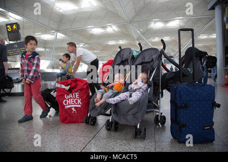 10 Monate altes Baby Zwillinge in einem Doppelbuggy unbeaufsichtigt am Stansted Airport, Großbritannien Stockfoto