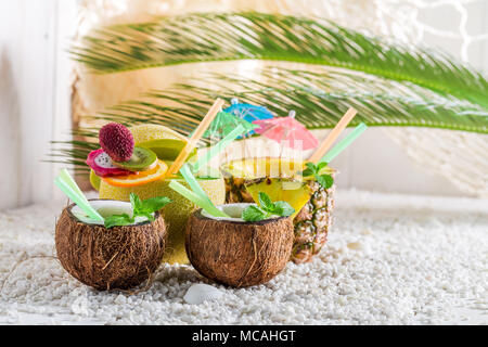 Süße Getränke in frischem Obst auf weißen Kieselsteinen Stockfoto