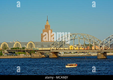 Turm von te Lettische Akademie der Wissenschaften, die zentrale Markthalle und Eisenbahnbrücke über Daugava riveron ein sonniger Tag mit blauen Himmel Stockfoto