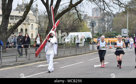 Brighton UK 15. April 2018 - ein Mann mit einem großen Kreuz verbindet die Tausende von Läufern Teil in den Brighton Marathon heute als auch für die Marathon Saison unter Weise in Großbritannien: Simon Dack/Alamy Leben Nachrichten erhält Stockfoto