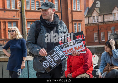 London, Großbritannien. 14. April 2018. Klasse Krieg bieten Poster an die Teilnehmer auf der Tour der wohlhabendsten Viertel Londons, vom Land Gerechtigkeit Netzwerk-LED zeigt Landbesitz in Großbritannien ist einer der größten Ungleichheit in der Welt, sowohl in den ländlichen Gegenden und in den Städten. Die Tour begann in Westminster, weitgehend von dem Herzog von Westminster, an relevanten Punkten auf den Grosvenor Estate, Park Lane, im Hyde Park, Grosvenor Crescent und Belgrave Square für Informationen und Reden zu stoppen, endend am 93 Hektar des Cadogan Immobilien, die wohlhabendste Teil von Kensington & Chelsea für eine Abschlusskundgebung. Ungleiche o Stockfoto