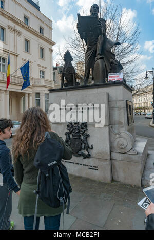 London, Großbritannien. 14. April 2018. "Die Grosvenor Familie kam nach England mit William der Eroberer und haben Land in Cheshire seit dieser Zeit", sagt eine Plakette auf der Seite - und sie besitzen auch einen grossen Klumpen von London. Eine Tour der wohlhabendsten Viertel Londons, vom Land Gerechtigkeit Netzwerk-LED zeigt Landbesitz in Großbritannien ist einer der größten Ungleichheit in der Welt, sowohl in den ländlichen Gegenden und in den Städten. Die Tour begann in Westminster, weitgehend von dem Herzog von Westminster besessen, und stoppen Sie bei relevanten Punkte auf der Grosvenor Estate, Park Lane, im Hyde Park, Grosvenor Crescent und Belgrave Square für Informati Stockfoto