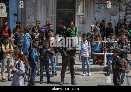 Gaza, Palästina. 15 Apr, 2018. dpatop - eine palästinensische Militante wacht in der Straße bei der Beerdigung des Islamischen Djihad Militanten, welche bei einer Explosion getötet wurden, in Rafah im südlichen Gazastreifen, 15. April 2018. Al-Quds-Brigaden, der bewaffnete Arm der Palästinensischen Islamischen Dschihad Organisation, sagte, dass vier seiner Kämpfer während einer Mission der militärischen Einrichtung, Zubereitungen und Verarbeitung getötet wurden. Foto: Wissam Nassar/dpa Quelle: dpa Picture alliance/Alamy leben Nachrichten Stockfoto