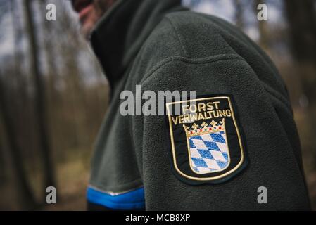 03 April 2018, Deutschland, Werneck: Ralf Petercord, Leiter der Abteilung Wald des Bayerischen Landesanstalt für Forstwirtschaft trägt ein Abzeichen auf der Jacke, die lautet "forstverwaltung" (Lit. forstverwaltung). In diesem Jahr, Eichen in Teilen der Freistaat Bayern angesichts der akuten Bedrohung von zigeunermotten. Foto: Nicolas Armer/dpa Stockfoto