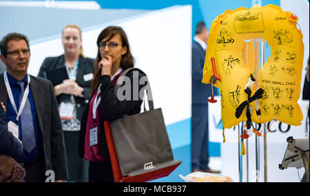 10 April 2018, Deutschland, Hamburg: Messe Besucher betrachten eine Schwimmweste auf der Aircraft Interiors Expo, der Messe für Flugzeuge Outfits und Befestigungen. Foto: Axel Heimken/dpa Stockfoto