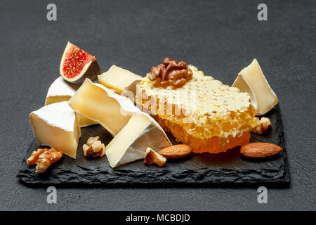 Camembert Käse mit Honig, Feigen, Walnüsse auf Stein board Stockfoto