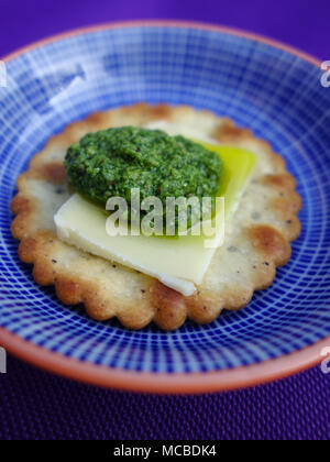 Bärlauch Pesto auf einem Cracker mit einem Stück Parmesan Stockfoto