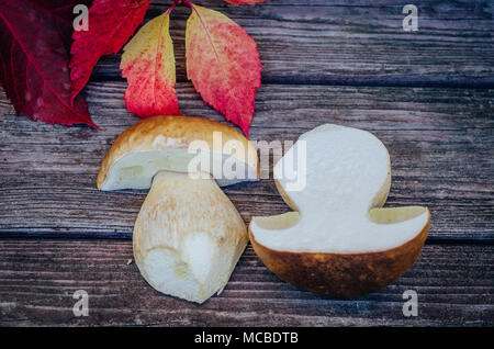 Steinpilze und wilder Wein auf hölzernen Tisch Stockfoto
