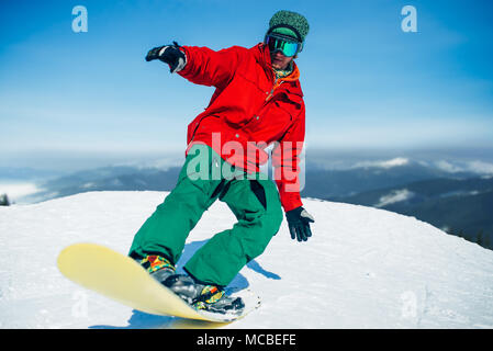 Snowboarder in Gläsern wirft mit Board in den Händen Stockfoto