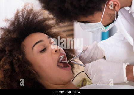 Nahaufnahme einer jungen Frau, die sich einer zahnärztlichen Behandlung in der Klinik Stockfoto