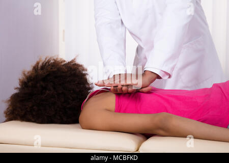 Nahaufnahme der Physiotherapeut Hand geben Zurück Massage Patientin in der Klinik Stockfoto