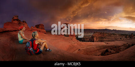 Wanderer sitzen an Zarten Arch Arch, Dämmerung, Arches National Park, in der Nähe von Moab, Utah, USA, Nordamerika Stockfoto