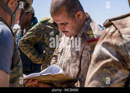 Ein Mitglied der irakischen Grenze wache Bewertungen Informationen über Ausrüstung aus der U.S. Army 249th Composite Supply Company übertragen werden, 82nd Airborne Division, im Camp Taji, Irak, 26. März 2018. Die USA bietet Ausbildung und Ausrüstung der irakischen Sicherheitskräfte durch die National Defense Authorization Act Geschäftsjahr 2015 geprüft; der Irak auszubilden und auszurüsten. Ausbildung und Ausrüstung zur Unterstützung der Combined Joint Task Force - inhärenten Lösen Mission zu besiegen und ISIS sicheren Zufluchtsort verweigern durch Erstellen und Aktivieren von irakischen Truppen zu verteidigen und ihr Land von sicheren Terroris Stockfoto