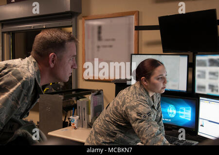 Kol. Benjamin Spencer, 319 Air Base Wing Commander (rechts), Slips Mitglied der 319 Sicherheitskräfte Squadron während Guard mount März 28, 2018, Grand Forks Air Force Base, N.D. Er und Chief Master Sgt. Brian Thomas, 319 ABW Befehl Chief, nutzten die Gelegenheit Verteidiger für ihren Einsatz und ihre Professionalität zu applaudieren, und erkannte die Herausforderungen beim Schutz der Flieger und ihre Familien. Stockfoto