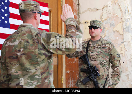 Maj. Patrick Devine (links), Kaplan, Zug, Beratung, Unterstützung und Command-South 2 Infantry Brigade Combat Team, 4 Infanterie Division, amtiert die Rekrutierung Zeremonie für Staff Sgt. Marcus S. Hebeln, religiöse Angelegenheiten noncommissioned Officer, Taac - Süd und 2 IBCT, 4. Inf. Div., 17. März 2018, in Kandahar, Afghanistan. Stockfoto