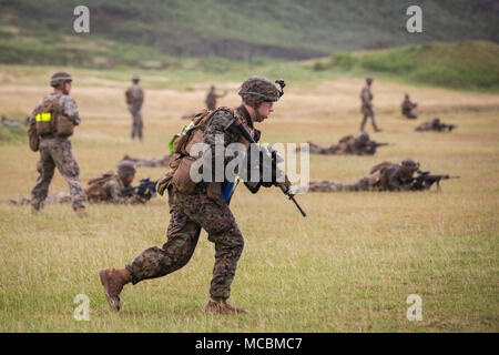 Us Marine Corps Pfc. Samuel Hollenbeck, Angriff Mann mit Bravo Bravo Company (Co), 1., 3. Marine Regiment, Buddy stürzt während einer Gruppe übung in der Kaneohe Bay Bereich Training Service, Marine Corps Base Hawaii, März 22, 2018 unterstützt. Bravo Co. genutzten Maschinengewehr Unterdrückung und Mörtel Feuer auf simulierten feindlichen Kräfte, während die Infanteristen in Richtung sie angriff. Diese kombinierte-kräfte Übung war der letzte Tag der Schulungsveranstaltung des Bataillons, Übung Bougainville, eine jährliche Übung, dass Pre stärkt - bereitstellungsbereitschaft. Stockfoto