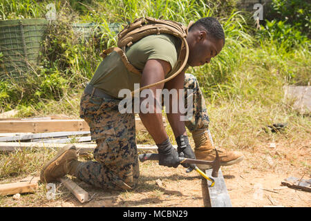 Lance Cpl. Karenz Wright, ein Combat engineer mit 2Nd Platoon, einer Co., 9 Techniker, 3. Marine Logistics Group, entfernt der Nägel, die aus einer früheren Südwesten Asien Hütte während der verschiedenen Übungen März 26, 2018, Camp Hansen, Okinawa, Japan. Vertikalen Aufbau Schulung bereitet Marines für ähnliche Projekte, die Sie mit während der humanitären Hilfsmaßnahmen übertragen werden. Die Ingenieure wurden beauftragt, die Nägel aus dem Holz zu entfernen und entsorgen Sie diese getrennt durch Verteidigung Umnutzung Marketing Office (DRMO) Vorschriften. Wright ist ein Eingeborener von Saint Louis, Missou Stockfoto