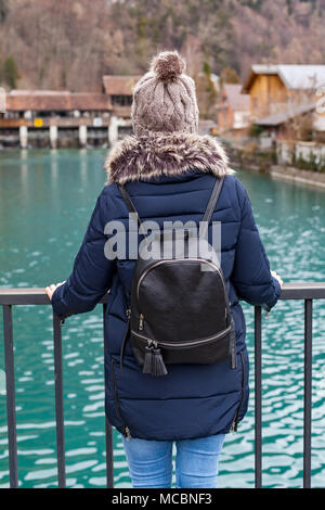 Junge weibliche Touristen in Interlaken, Schweiz zurück - mit Blick auf das klare Wasser der Aare Stockfoto