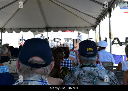 Aktuelle und frühere Coast Guard Cutter Sherman Crewmitglieder, Familienmitglieder und Freunde hören, Kapitän Steven Whittrock, Sherman's kommandierenden Offizier, als er Adressen aus dem Publikum während des Sherman Stilllegung Zeremonie in Honolulu, März 29, 2018. Neue Anlagen, wie z.b. die National Security Cutter und Offshore Patrol Scherkörbe und Schermesser Fast-Response wird die Überalterung der Flotte von 378 ersetzen - Fuß hohe Ausdauer Fräser wie die Sherman, die Verdienstvoller in der Küstenwache seit fast 50 Jahren serviert. Stockfoto