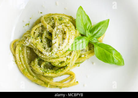 Pasta Spaghetti mit Pesto grüne Soße in Genua (Genova) Italien auf weiße Platte Hintergrund, Nudeln mit Basilikum Pesto Kräuter Hintergrund. Stockfoto