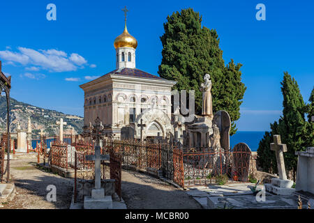 Alte russische orthodoxe Kapelle unter Kreuze, Statuen und Gräber auf dem alten Friedhof mit Blick auf das Mittelmeer in Menton, Frankreich. Stockfoto