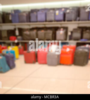 Unscharfes Bild. Verkauf im Laden. Reisen Koffer in verschiedenen Größen und Farben und Waren, Reisenden Koffern im Shop zum Verkauf. Stockfoto