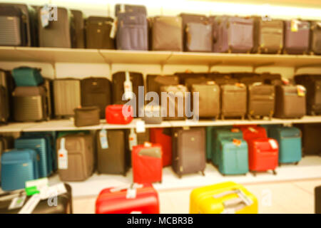 Unscharfes Bild. Verkauf im Laden. Reisen Koffer in verschiedenen Größen und Farben und Waren, Reisenden Koffern im Shop zum Verkauf. Stockfoto