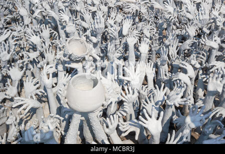 Detail Kunst, schöne des berühmten Wat Rong Khun (weiße Tempel) in der Provinz Chiang Rai im Norden von Thailand. Hände aus der Hölle im Konzept Hintergrund. Stockfoto