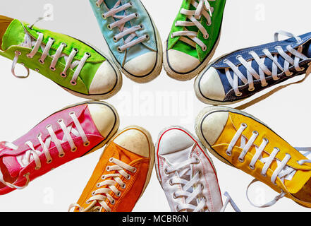 Bunte Schuhe auf weißem Hintergrund. Cool Jugend bunte weiß gelb grün blau schwarz orange Turnschuhe stehen im Kreis auf weißem Hintergrund. mit Co Stockfoto