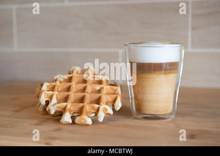 Glas Tassen multilayer Kaffee mit Mini stroopwafel, syrupwaffles Cookies auf hellgrauem Hintergrund mit Kopie Raum. Waffel cookies Stockfoto