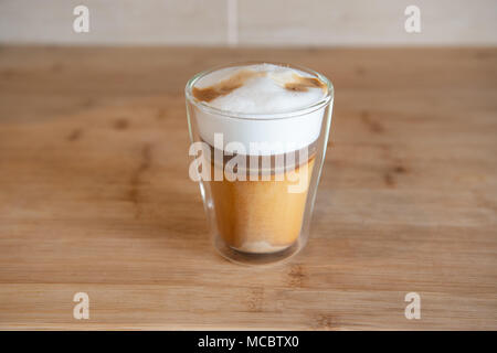 Multilayer Kaffee oder Cappuccino in einem Glas Schale auf Holztisch. Stockfoto