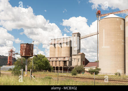 FICKSBURG, SÜDAFRIKA - 12. MÄRZ 2018: die Relikte der Dampflok Ära neben Silos in Ficksburg in der Provinz Stockfoto