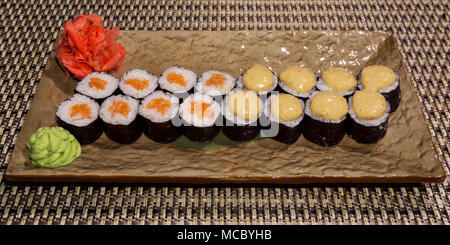 Zwei Arten von traditionellen japanischen Sushi Rollen futomaki auf einem rechteckigen stilisierte Platte closeup Stockfoto