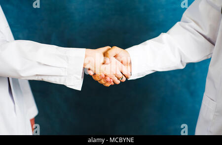Zwei Ärzte die Hände schütteln, arbeiten im Team Stockfoto