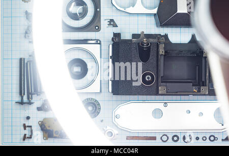Teile sind vollständig demontiert alten retro Film SLR Kamera auf Millimeterpapier, close-up Stockfoto