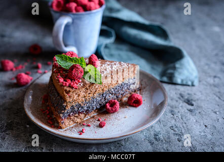 Eine Scheibe von Kakao Kuchen mit Mohn und Kokos Füllung, mit freeze dekoriert - getrocknete Himbeeren Stockfoto