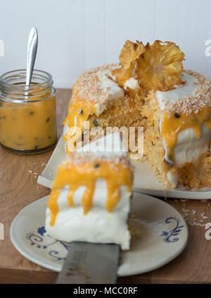 In Scheiben geschnittene Ananas und Kokosnuss Layer Cake, serviert mit Passionsfrucht Soße auf handgefertigte Keramik Platten. Stockfoto