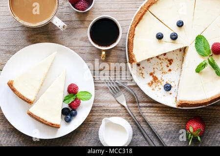 Hausgemachte klassische New York Käsekuchen und Kaffee auf Holztisch. Ansicht von oben Stockfoto