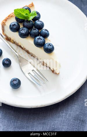 Stück Käsekuchen mit frischen Blaubeeren auf weiße Platte. Selektiver Fokus Stockfoto
