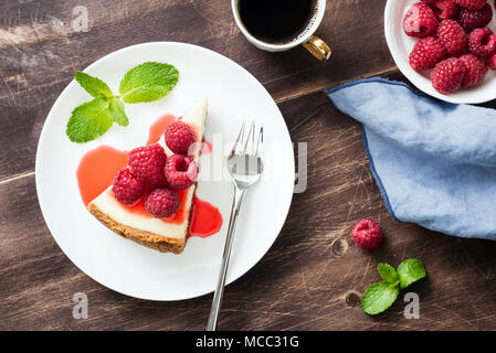 Käsekuchen mit Himbeeren und Berry Soße auf Holztisch. Ansicht von oben, selektiver Fokus Stockfoto