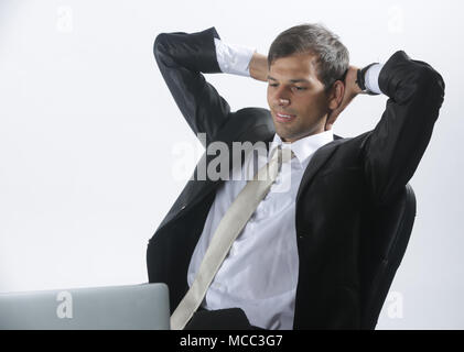 Mann im Hemd mit Laptop und das Denken in seinem Büro Stockfoto