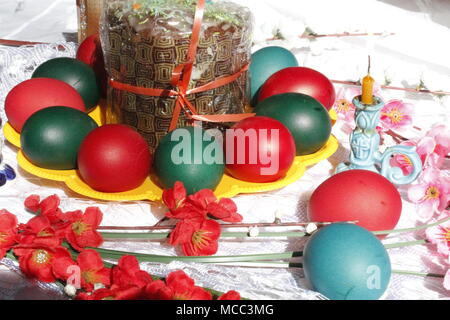 Traditionell helle rote Eier mit Kuchen und Kerzen Blumen für die Dekoration zu Ostern Urlaub lackiert Stockfoto