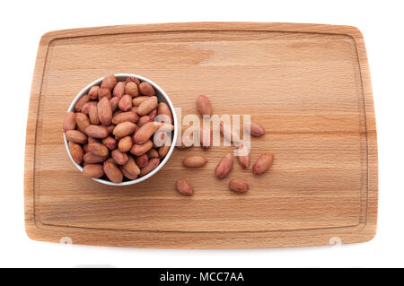 Peanut Körner in einer Schale auf einem Schneidebrett aus Holz. Stockfoto