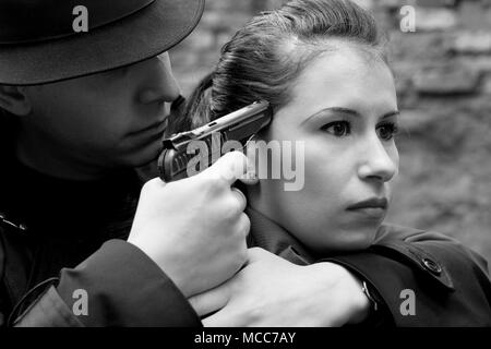 Monochrome Portrait von Mann bedroht die Frau mit einer Pistole Stockfoto