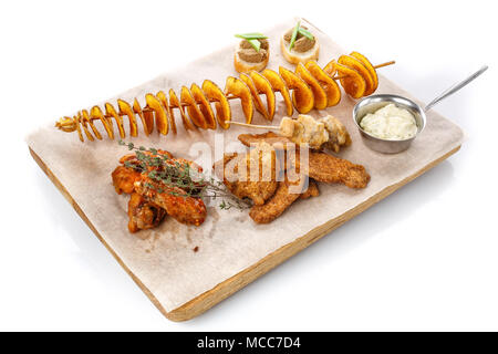 Stellen Sie Snacks, Bier. Kartoffelchips, Chicken Wings, basturma, Käse und Chicken Wings auf einem Holzbrett. Stockfoto