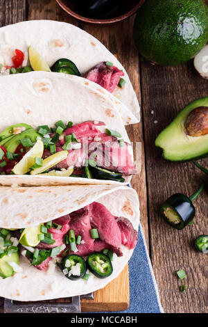 Tacos mit Rindfleisch Steak und Gemüse auf Weizenmehl Tortillas, mexikanischen Stil Mahlzeit Stockfoto