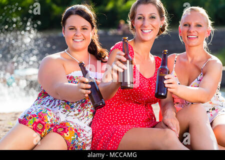 Freunden Bier trinken am Strand am Fluss Stockfoto